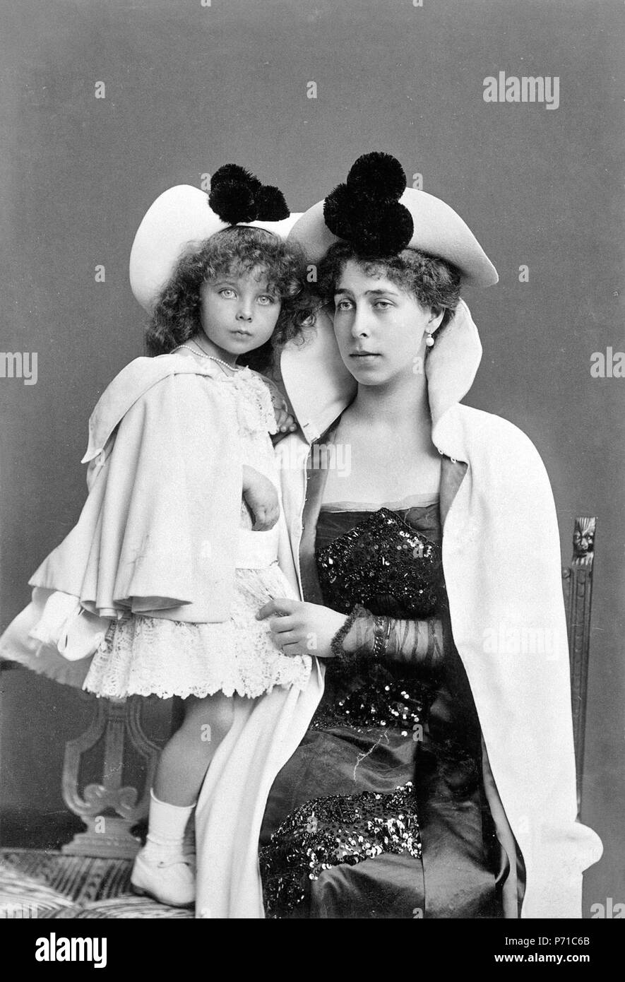 Inglese: Victoria Melita, Granduchessa di Hesse, seduto con sua figlia, la  principessa Elisabetta, in piedi su una sedia accanto a lei. Entrambi hanno  indossare mantelli e simili cappelli, rifinito con 3 pompon