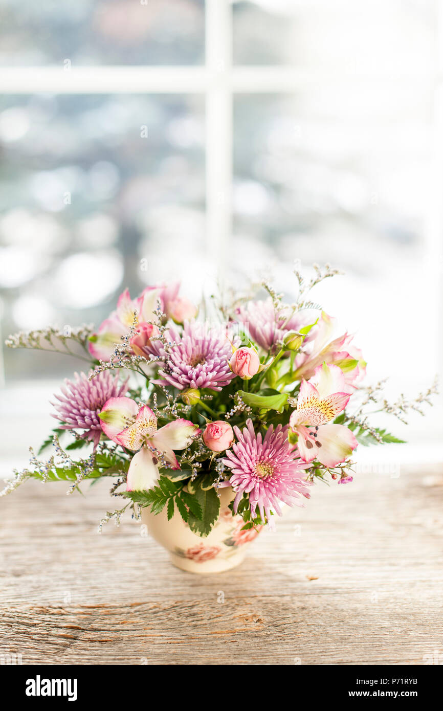 Bouquet di fiori colorati disposti in piccolo vaso Foto Stock