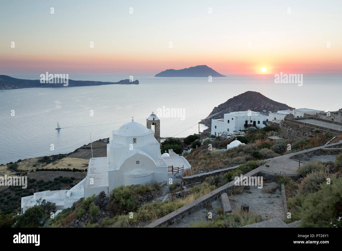 Bianco chiesa greca e Milos Bay dal castello di Plaka al tramonto, Plaka, Milos, Cicladi, il Mare Egeo e le isole greche, Grecia, Europa Foto Stock