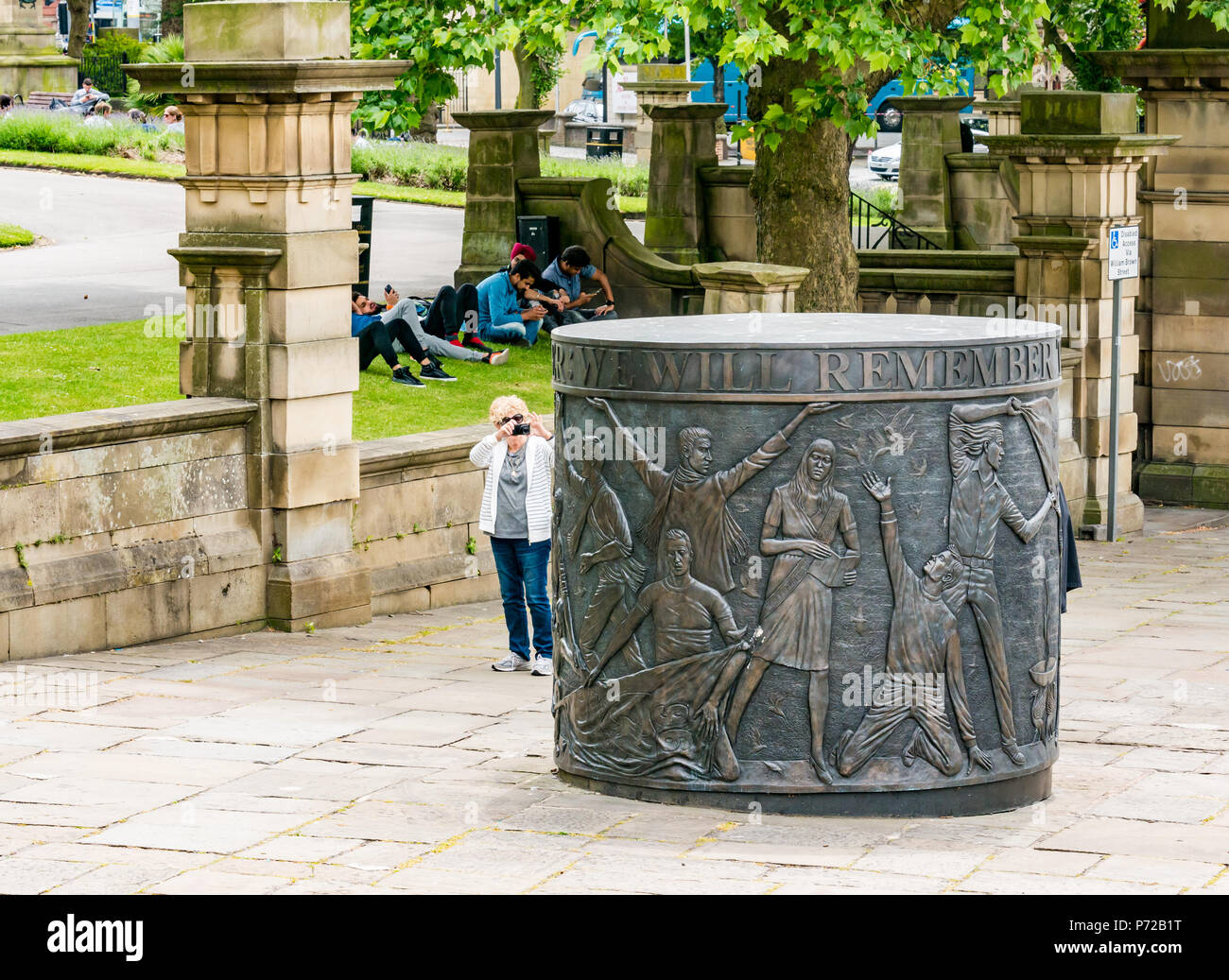 Donna prendendo foto del monumento di Hillsborough Memorial da Tom Murphy, St John's Gardens, Liverpool, in Inghilterra, Regno Unito Foto Stock