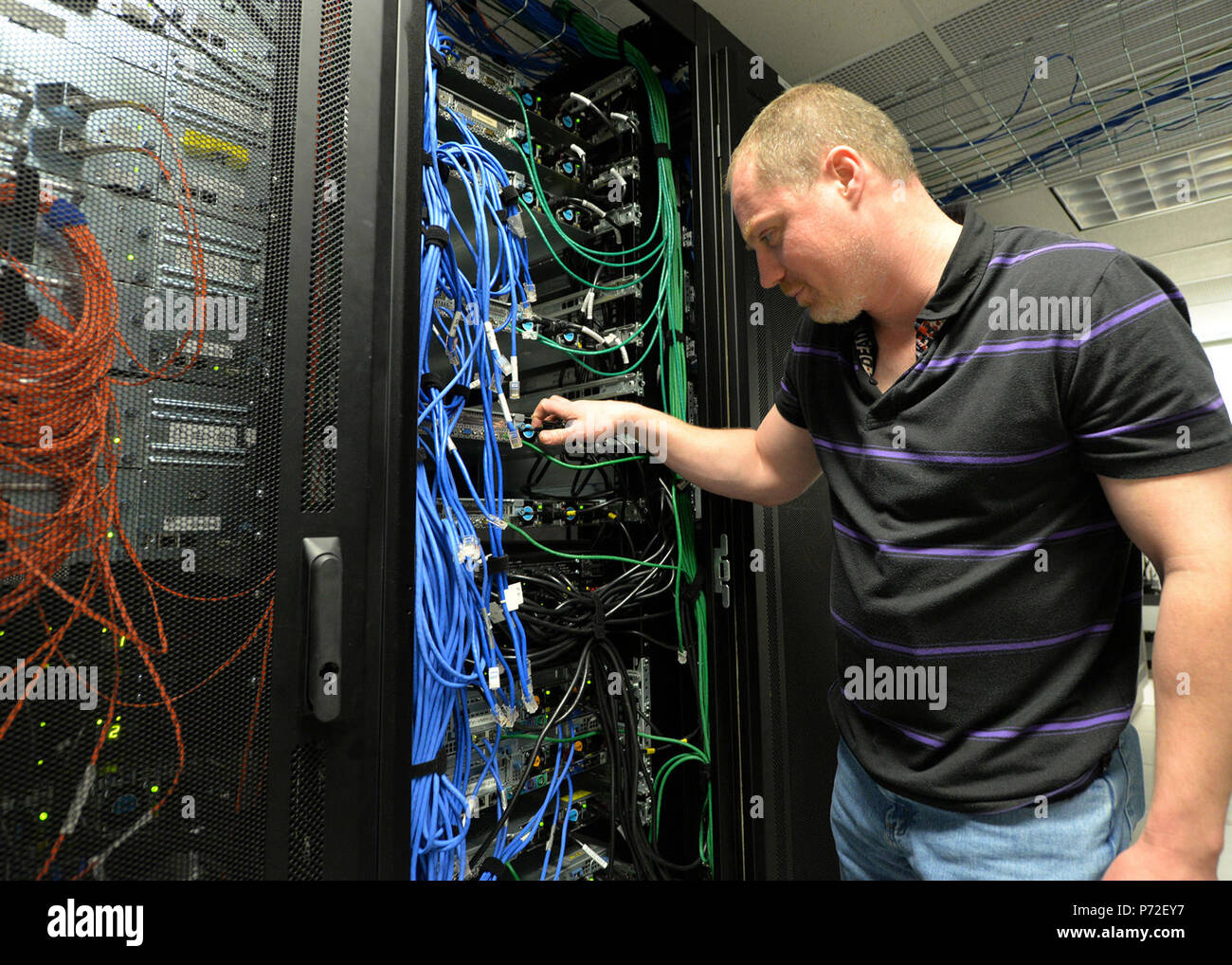 Jason Slusher, 88th squadrone di comunicazione delle operazioni del server di amministratore di sistema, controlla una connessione del server alla Wright-Patterson Air Force Base telaio principale del computer, 11 maggio 2017. Il funzionamento del server team garantisce la massima capacità di accesso a WPAFB sistemi informatici con risposta rapida soluzioni per anomalie di funzionamento. Foto Stock