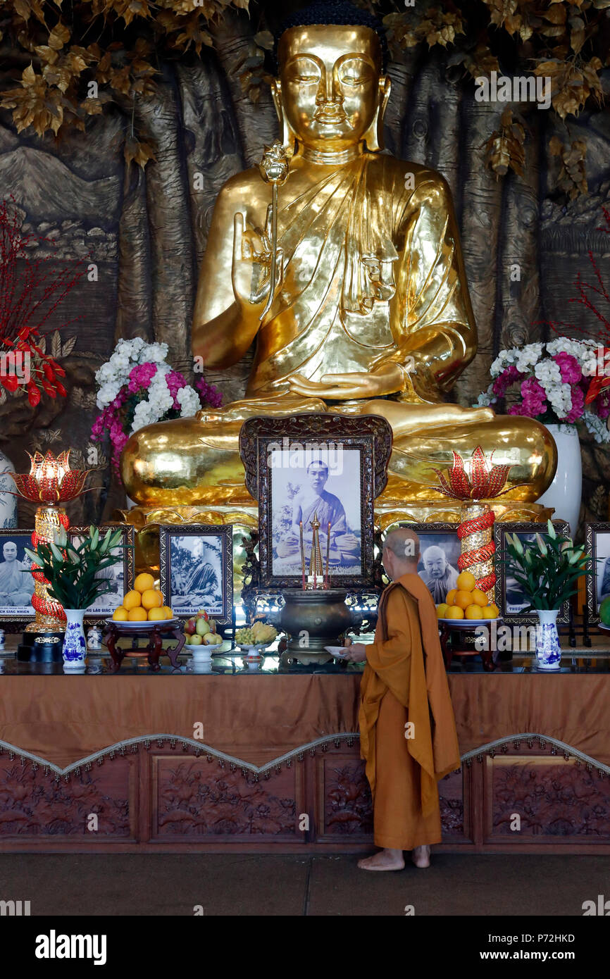 Golden Buddha con fiore di loto e monaco buddista, Minh Dang Quang tempio buddista, Ho Chi Minh City, Vietnam, Indocina, Asia sud-orientale, Asia Foto Stock