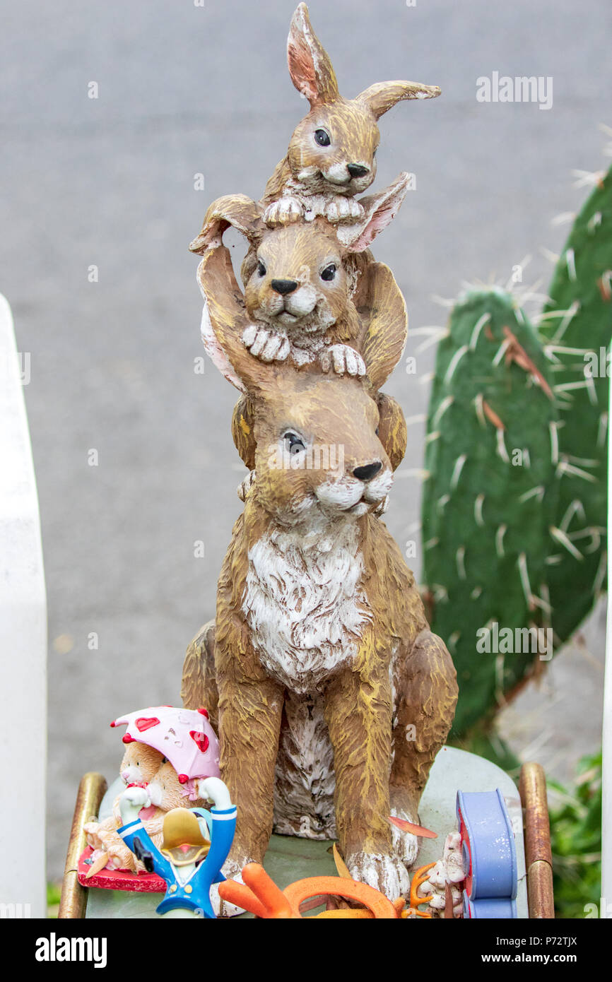 Whimsical arte giardino decorazione - Madre coniglio con due coniglietti sulla sua testa Foto Stock