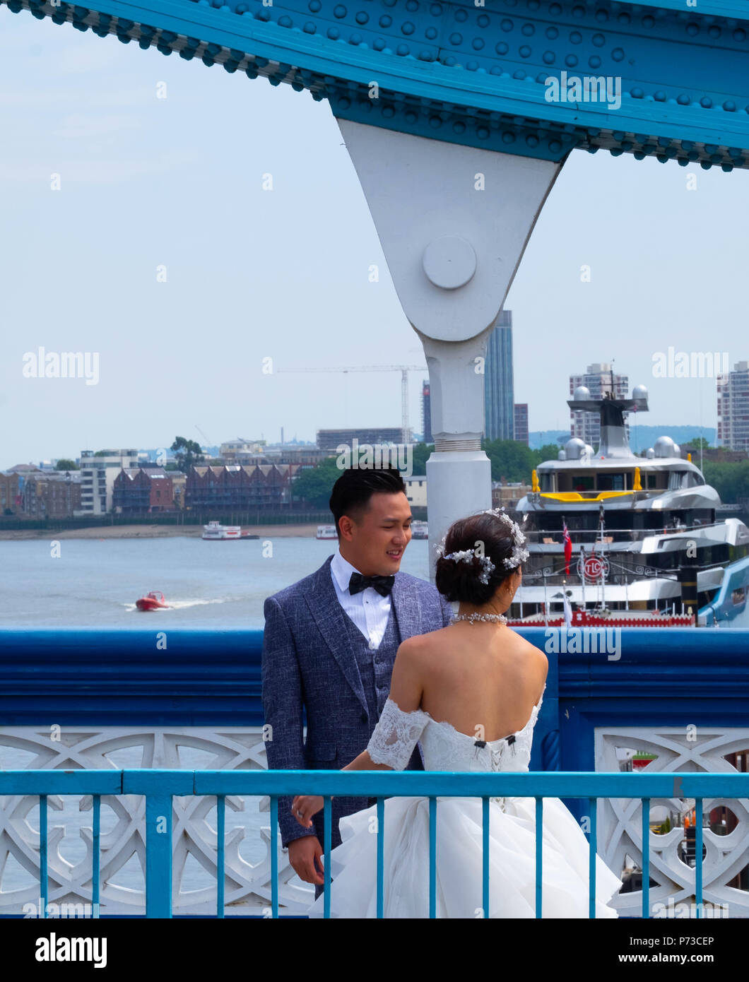 Londra, Inghilterra. 4 luglio 2018. Un paio hanno il loro matrimonio le foto scattate con il Tower Bridge di Londra tra tutti i turisti in un'altra giornata molto calda. La presente ondata di caldo è impostata per continuare. ©Tim anello/Alamy Live News Foto Stock