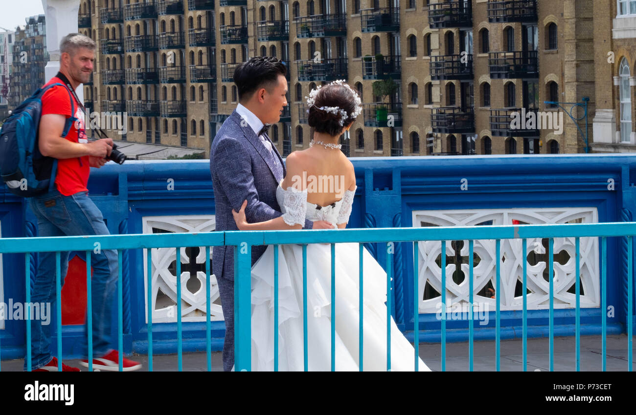 Londra, Inghilterra. 4 luglio 2018. Un paio hanno il loro matrimonio le foto scattate con il Tower Bridge di Londra tra tutti i turisti in un'altra giornata molto calda. La presente ondata di caldo è impostata per continuare. ©Tim anello/Alamy Live News Foto Stock