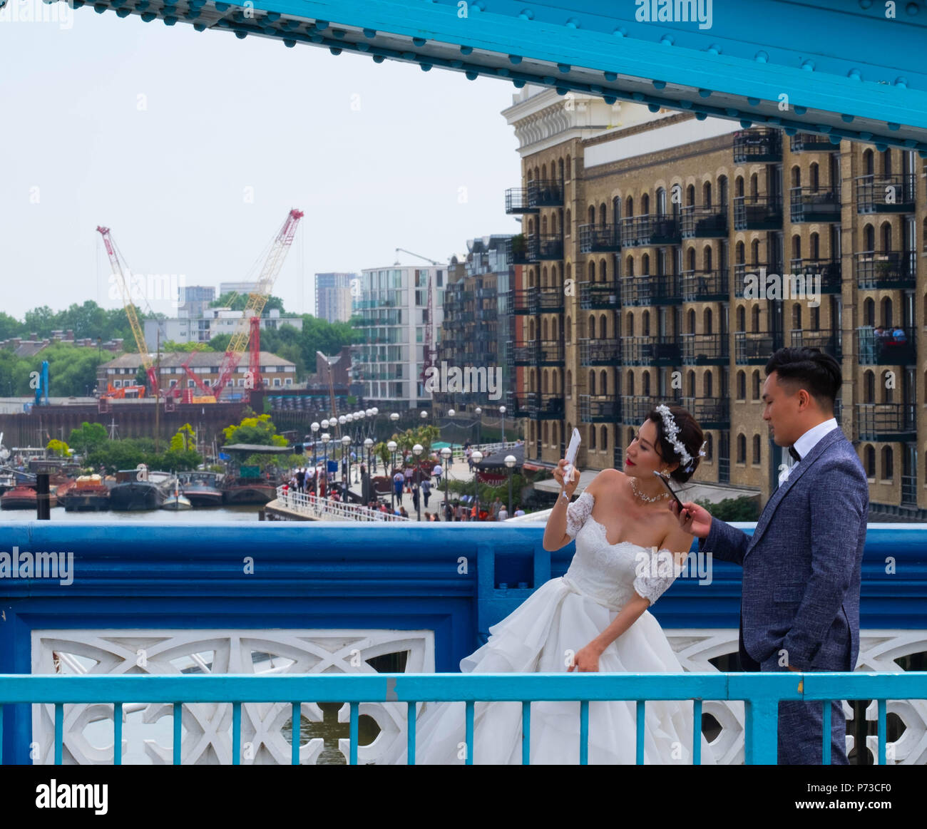 Londra, Inghilterra. 4 luglio 2018. Un paio hanno il loro matrimonio le foto scattate con il Tower Bridge di Londra tra tutti i turisti in un'altra giornata molto calda. La presente ondata di caldo è impostata per continuare. ©Tim anello/Alamy Live News Foto Stock