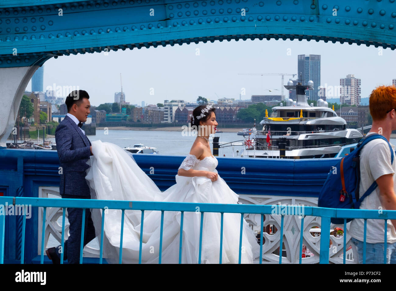 Londra, Inghilterra. 4 luglio 2018. Un paio hanno il loro matrimonio le foto scattate con il Tower Bridge di Londra tra tutti i turisti in un'altra giornata molto calda. La presente ondata di caldo è impostata per continuare. ©Tim anello/Alamy Live News Foto Stock