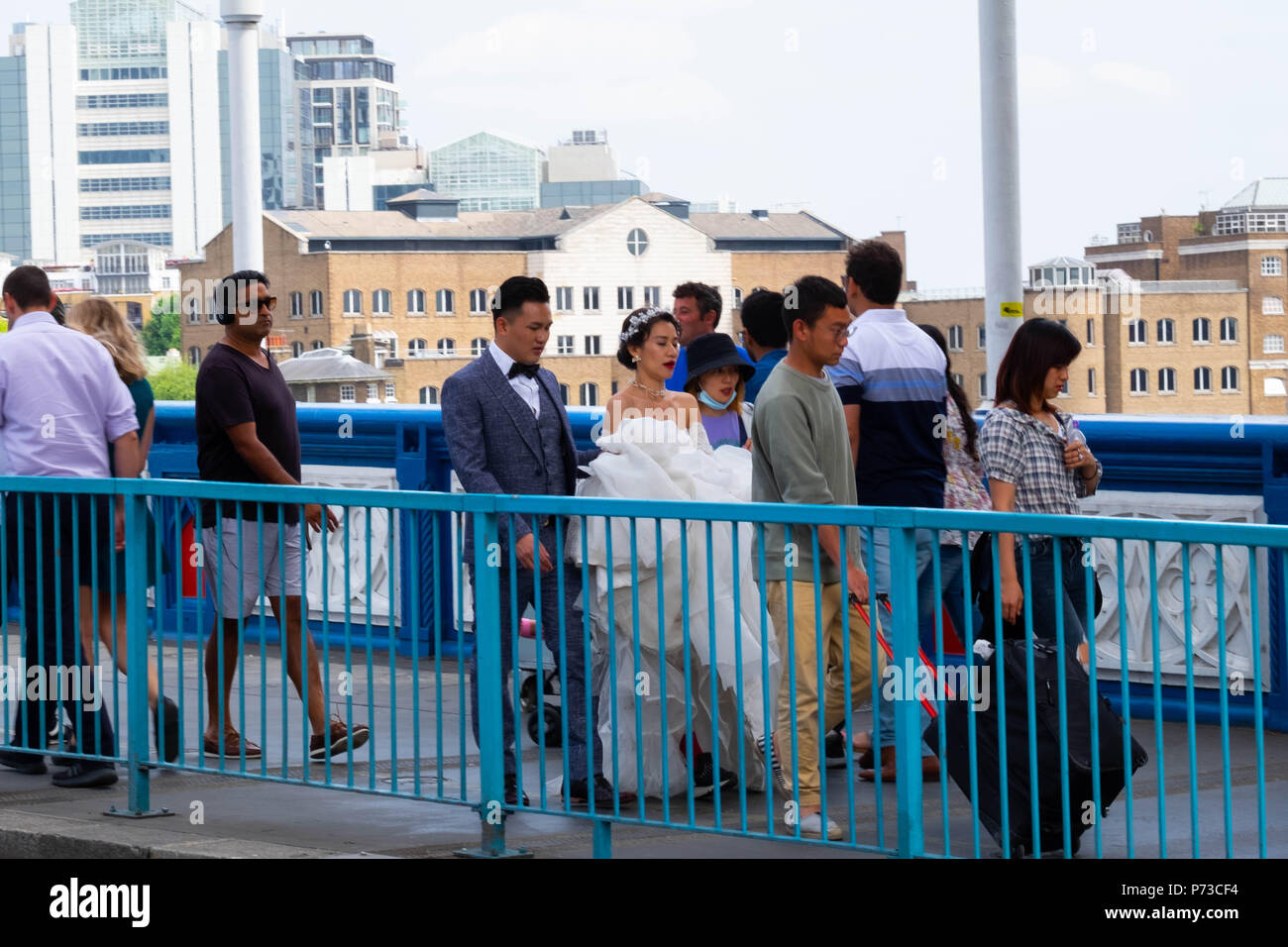 Londra, Inghilterra. 4 luglio 2018. Un paio hanno il loro matrimonio le foto scattate con il Tower Bridge di Londra tra tutti i turisti in un'altra giornata molto calda. La presente ondata di caldo è impostata per continuare. ©Tim anello/Alamy Live News Foto Stock