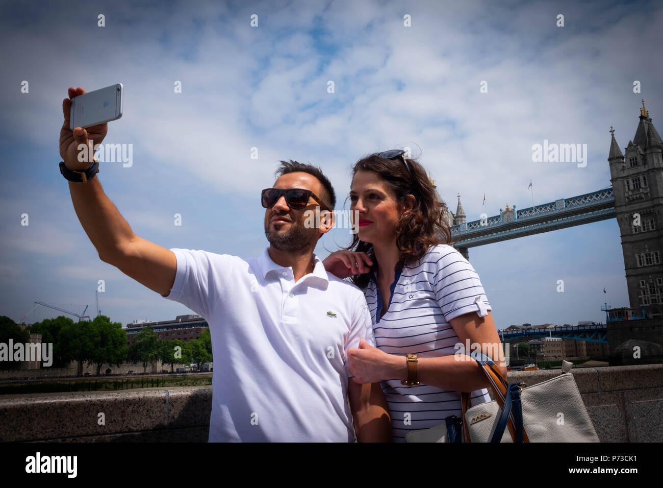 Londra, Inghilterra. 4 luglio 2018. La Georgia e il suo fidanzato, turisti provenienti dalla Grecia, prendere un selfie vicino al Tower Bridge su un'altra giornata molto calda. La presente ondata di caldo è impostata per continuare. ©Tim anello/Alamy Live News Foto Stock