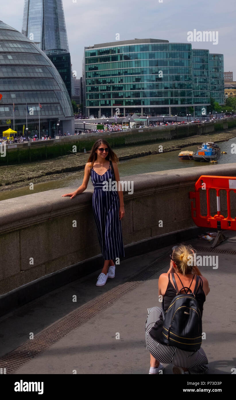 Londra, Inghilterra. 4 luglio 2018. Una giovane donna ha il suo foto scattata vicino il Tower Bridge di Londra su un'altra giornata molto calda. La presente ondata di caldo è impostata per continuare. ©Tim anello/Alamy Live News Foto Stock