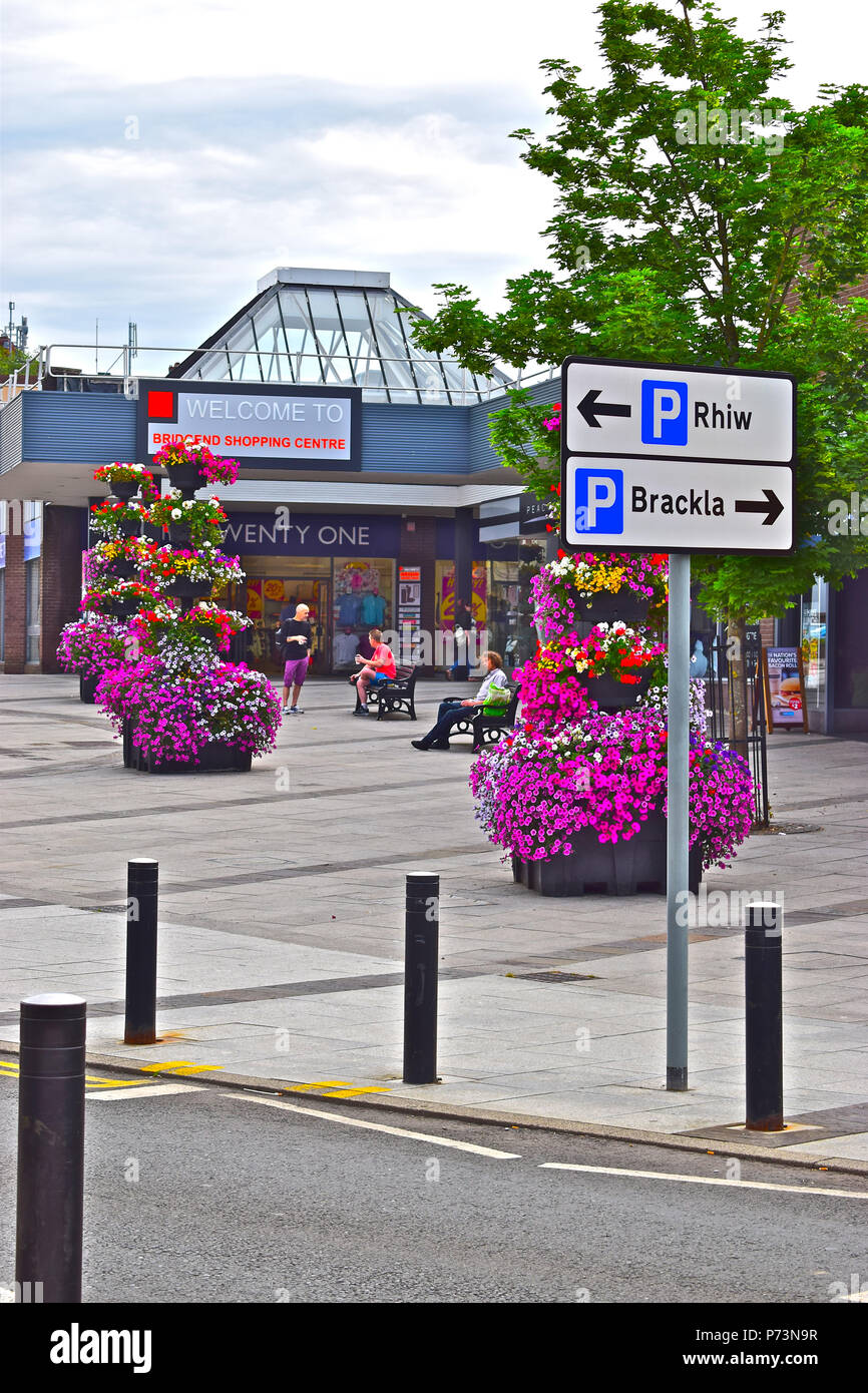 Attraenti composizioni floreali all'esterno dell'entrata anteriore al recentemente rinnovato e ridecorato Bridgend Shopping Center locali nel centro di Bridgend Foto Stock