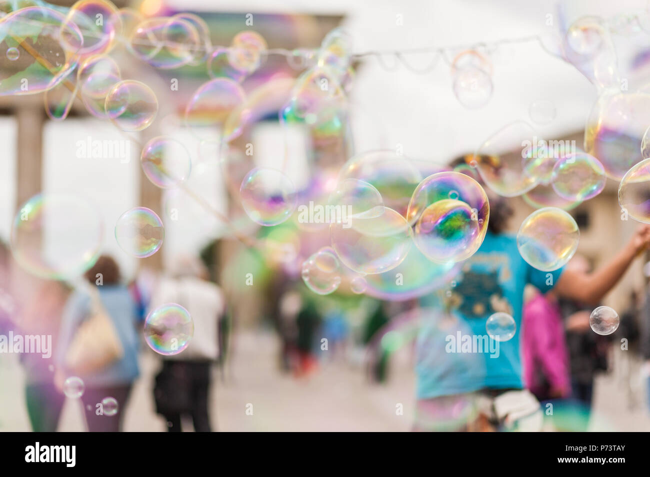 Colorate bolle di sapone galleggianti in primo piano. Street performer, busker, divertente la folla davanti alla Porta di Brandeburgo a Berlino. Foto Stock