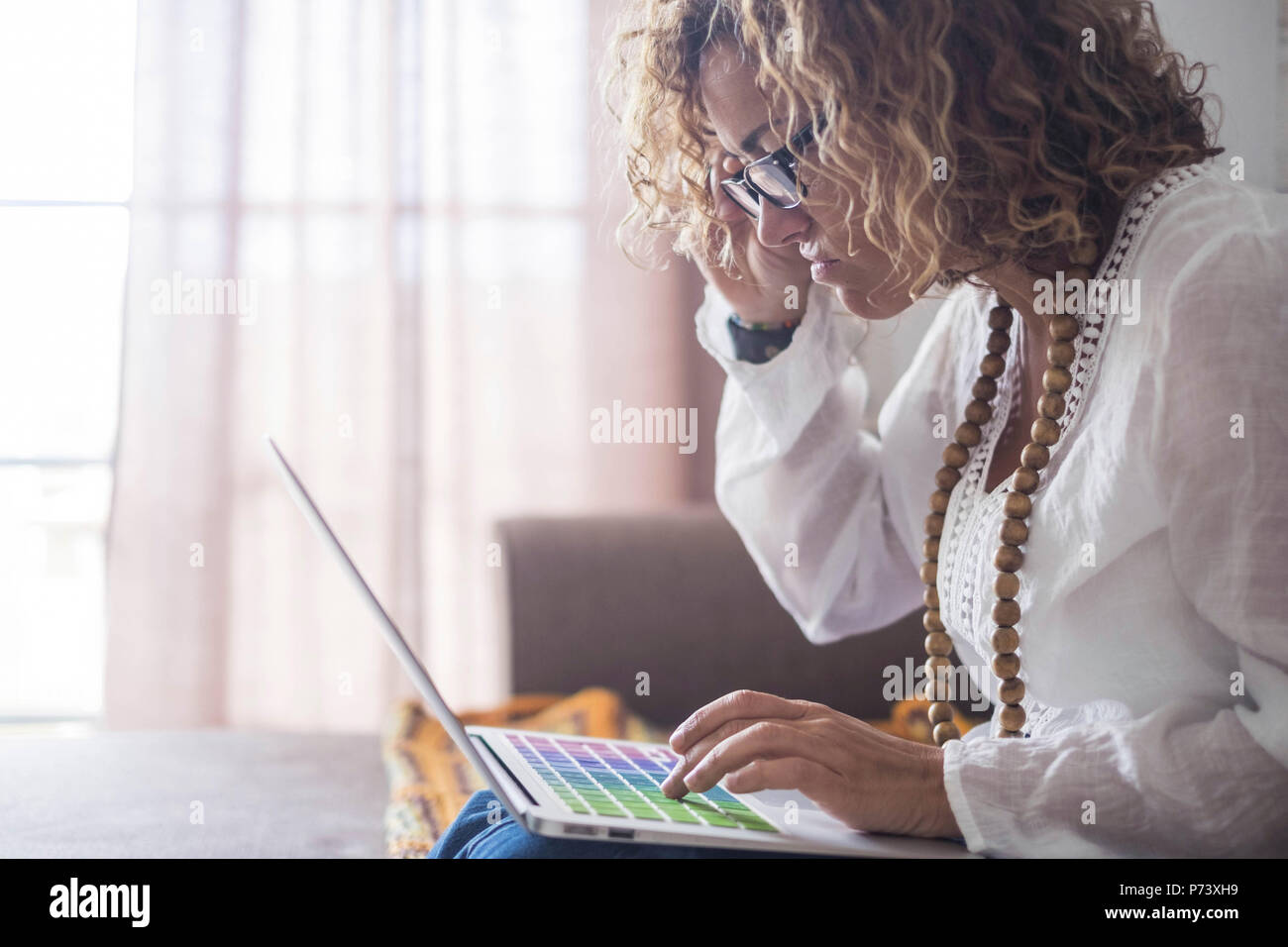 Infelici e brutto bella donna caucasica lavorando sul portatile a casa. alternativa concetto di ufficio per le persone che vivono in libertà lifestyle. comput colorati Foto Stock