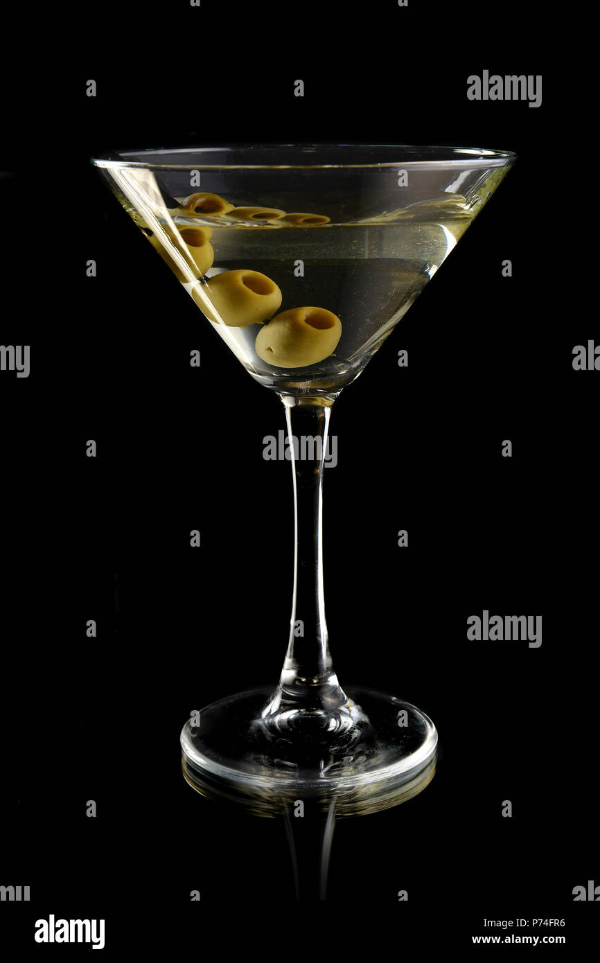 Martini con olive nere su sfondo nero Foto Stock
