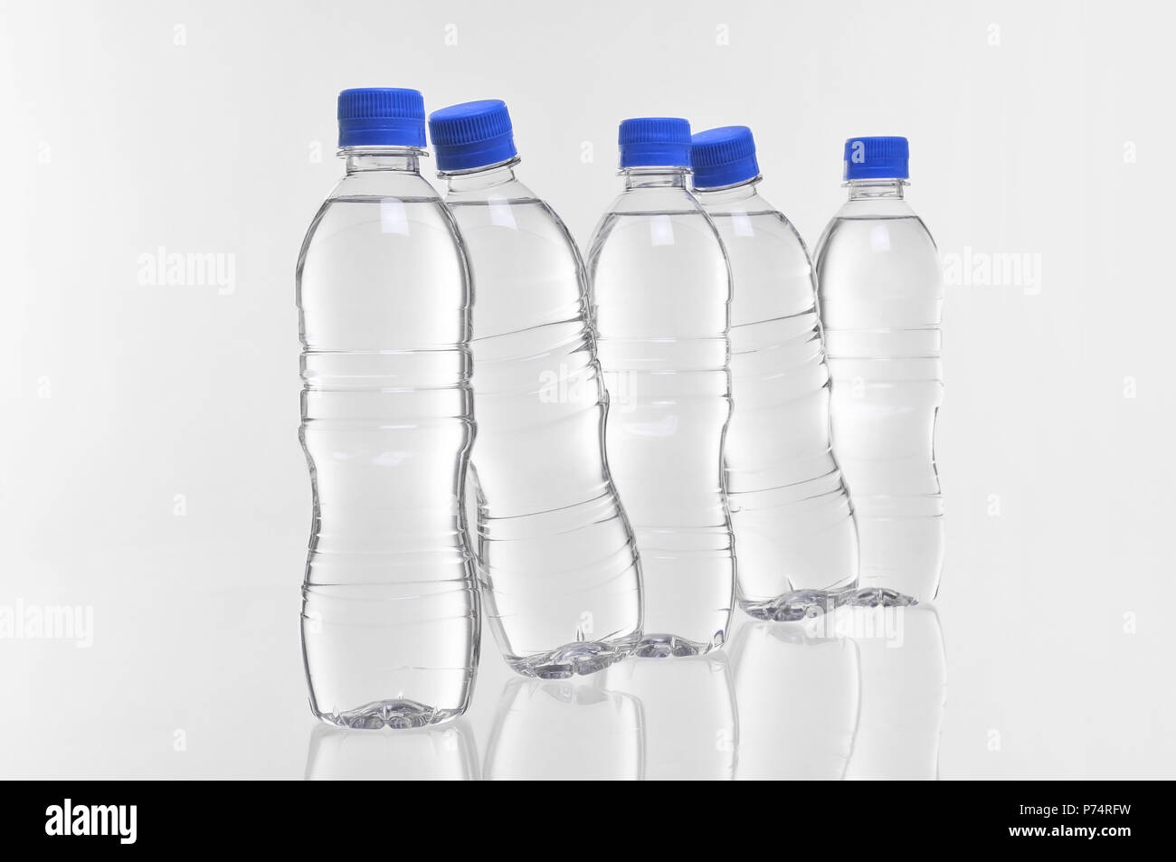 Cinque in plastica bottiglie di acqua con due in corrispondenza di un angolo Foto Stock