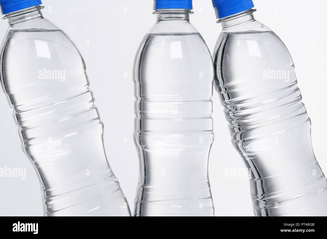 Primo piano della plastica tre bottiglie di acqua con i coperchi di colore blu Foto Stock