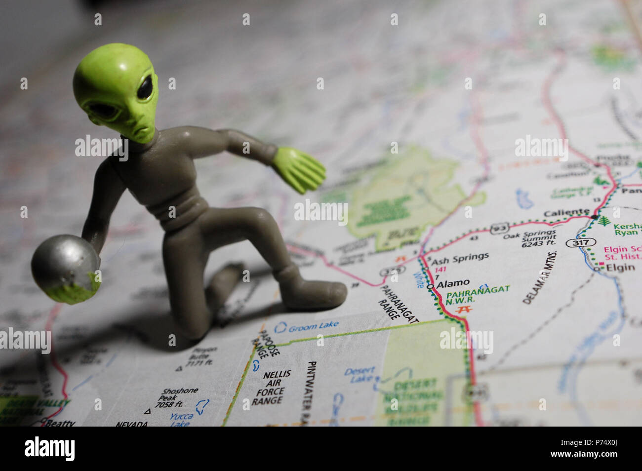 Un extraterrestre in miniatura nella foto con una mappa di Nellis Air Force Base in Nevada. Foto Stock