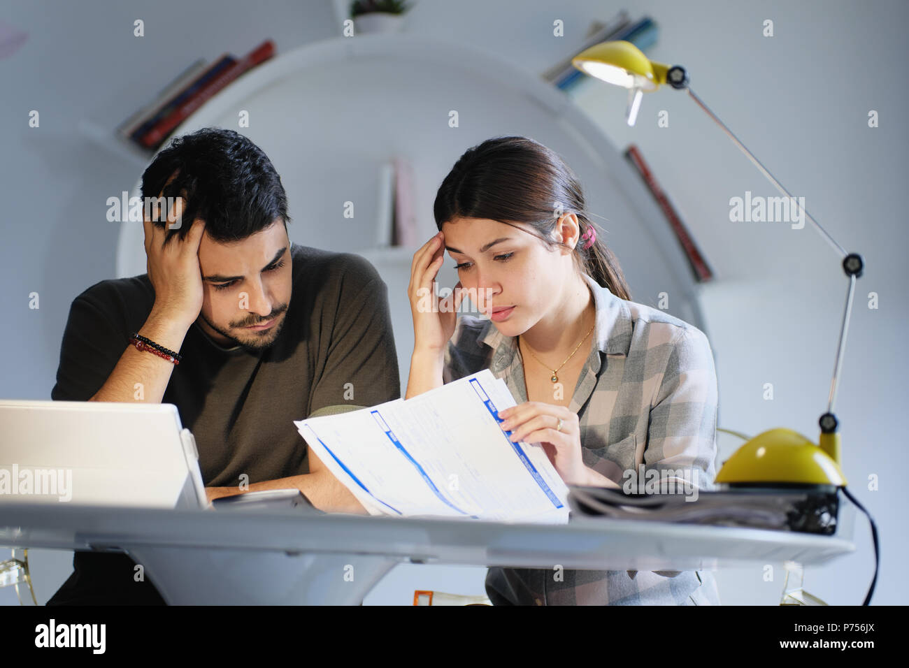 L uomo e la donna preoccupati per le tasse e bilancio familiare Foto Stock
