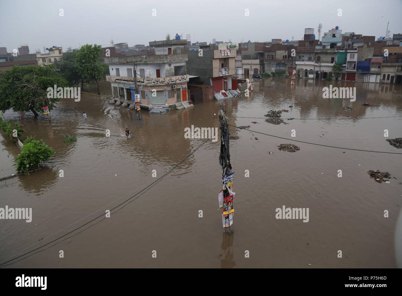 Pakistani residenti in Cina regime passando attraverso la strada allagata dopo le intense piogge monsoniche a Lahore. Il continuo pre-piogge monsoniche magia ha ancora una volta ha colpito la città. Almeno sei persone sono state uccise molti feriti in pioggia-incidenti correlati. Senza pietà come 238mm di pioggia ha continuato tre ore sommersi la maggior parte delle zone della città risultanti nella peggiore delle ipotesi gli inceppamenti di traffico nonché gravi disagi per i cittadini. Il Met Office ha detto che a causa di una pressione elevata correnti monsoniche penetrando nel paese, la capitale del Punjab, così come altre città, continuerà a ricevere acquazzone per i prossimi due d Foto Stock