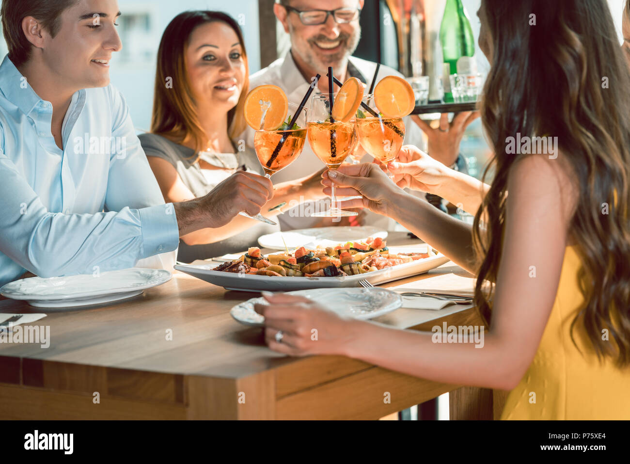 Bella donna tostare con il suo fidanzato e i suoi migliori amici Foto Stock