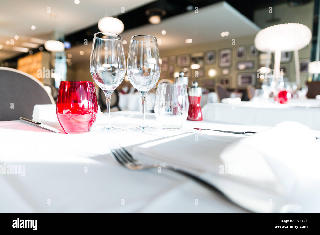 Illuminata di colore rosso e bianco Ristorante bicchieri da tavola con sfondo sfocato Foto Stock