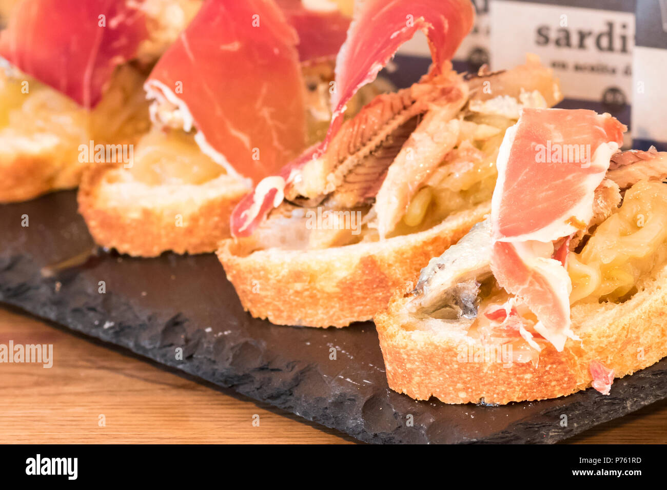 Pintxo di spagnolo jabugo prosciutto crudo con le cipolle caramellate e sardine da il cantabrico Foto Stock