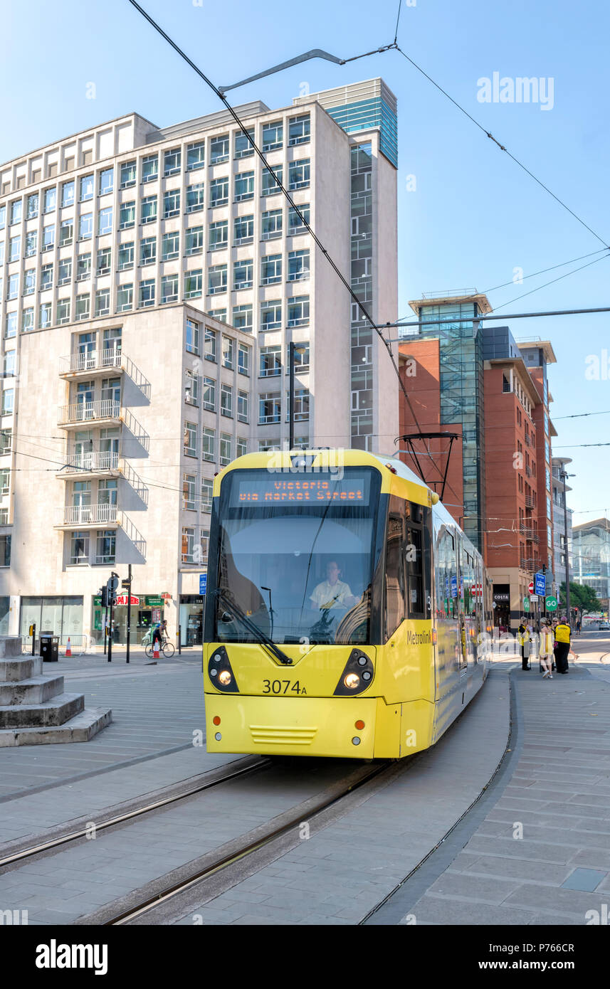 Moderno tram Metrolink prelevare i passeggeri presso il St Peters Square nel centro di Manchester, Regno Unito Foto Stock