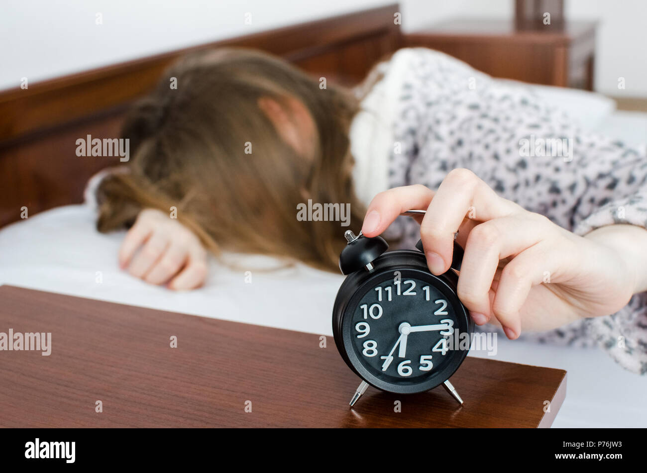 Giovane donna ragazza disattiva sveglia svegliarsi al mattino da una  chiamata. Irriconoscibile studente non vogliono svegliarsi presto per  andare a scuola o univerc Foto stock - Alamy