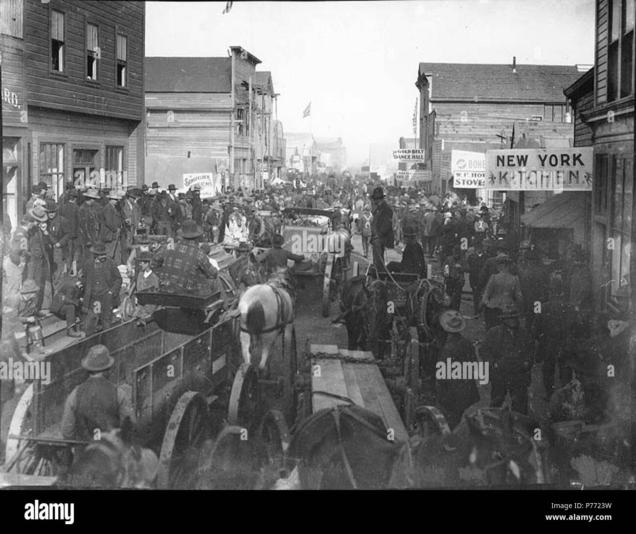 Inglese: Blocco delle persone sul Front St., Nome, Alaska, Luglio 1, 1900.  Inglese: Mostra traffico con cavallo e carri e persone; New York cucina e  cinghia oro Dance Hall a destra .