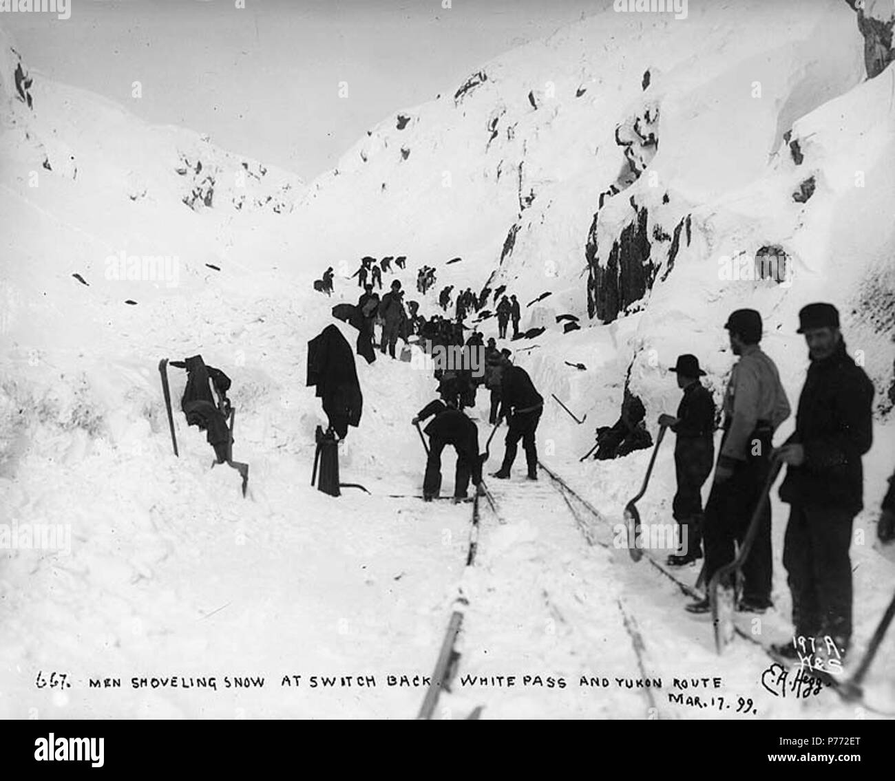 . Inglese: la cancellazione delle tracce del White Pass & Yukon Railroad dopo una tempesta di neve, Alaska, Marzo 17, 1899. Inglese: didascalia sull'immagine: 'Men spalare la neve a tornare White Pass e Yukon Route. Mar 17 '99.'" immagine originale in Hegg Album 2, pagina 38 fotografia originale da Eric A. Hegg 667; copiati da Webster e Stevens 197.A Klondike Gold Rush. Soggetti (LCTGM): rimozione della neve -- Alaska--Pass bianco; i binari della ferrovia--Alaska--Pass bianco soggetti (LCSH): Pass bianco (a.C.); valichi di montagna--Alaska; White Pass & Yukon Route (Azienda) . Adottate il 17 marzo 1899 2 la cancellazione delle tracce del Pass bianco &a Foto Stock