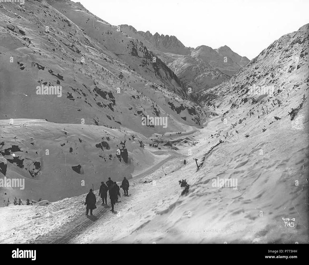 . Inglese: Klondikers escursioni attraverso il Canyon di intercettazione, Bianco Pass Trail, Alaska, ca. 1898. Inglese: Pass bianco Hotel è sepolto nella neve al centro dell'immagine . Sul verso dell'immagine: "Canyon di intercettazione sul bianco Pass trail. Nota le tende al centro della foto tutti ma coperto di neve. Questo è il sentiero del stampeder. Il White Pass e Yukon Railroad cerchi la montagna al centro dell'immagine, a metà strada verso l'alto.' didascalia sulla immagine: "Guardando giù canyon Cutoff mostra White Pass e Yukon RR sulla montagna" Immagine originale in Hegg Album 9, pagina 36 . Fotografia originale da Eric A. Hegg Foto Stock
