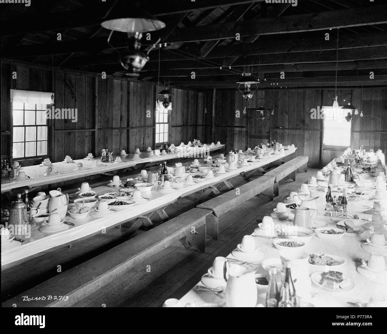 . Mess Hall. Inglese: Interno del telaio in legno mess hall presso il Registro Linco e legname Azienda Lindberg, Washington. La lunga in stile picnic tabelle sono impostati per un pasto. Serve piatti sono riempiti con il cibo. Panche di legno sono usati per posti a sedere. 3 Marzo 1920 7 Linco Log e legname Azienda Mess Hall Foto Stock . Mess Hall. Inglese: Interno del telaio in legno mess hall presso il Registro Linco e legname Azienda Lindberg, Washington. La lunga in stile picnic tabelle sono impostati per un pasto. Serve piatti sono riempiti con il cibo. Panche di legno sono usati per posti a sedere. 3 Marzo 1920 7 Linco Log e legname Azienda Mess Hall Foto Stock