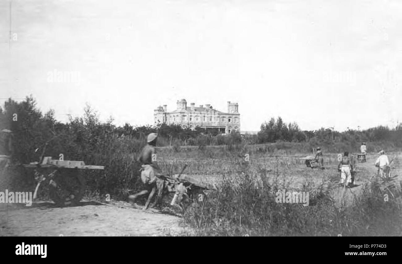 . Inglese: Uomini salpamento materiali attraverso il campo con grande casa in background, ca. 1898-1904 . Inglese: scritto sulla pagina: La casa Detring PH Coll 214.H26 . circa 1898-1904 9 uomini salpamento materiali attraverso il campo con grande casa in background, ca 1898-1904 (CHANDLESS 161) Foto Stock