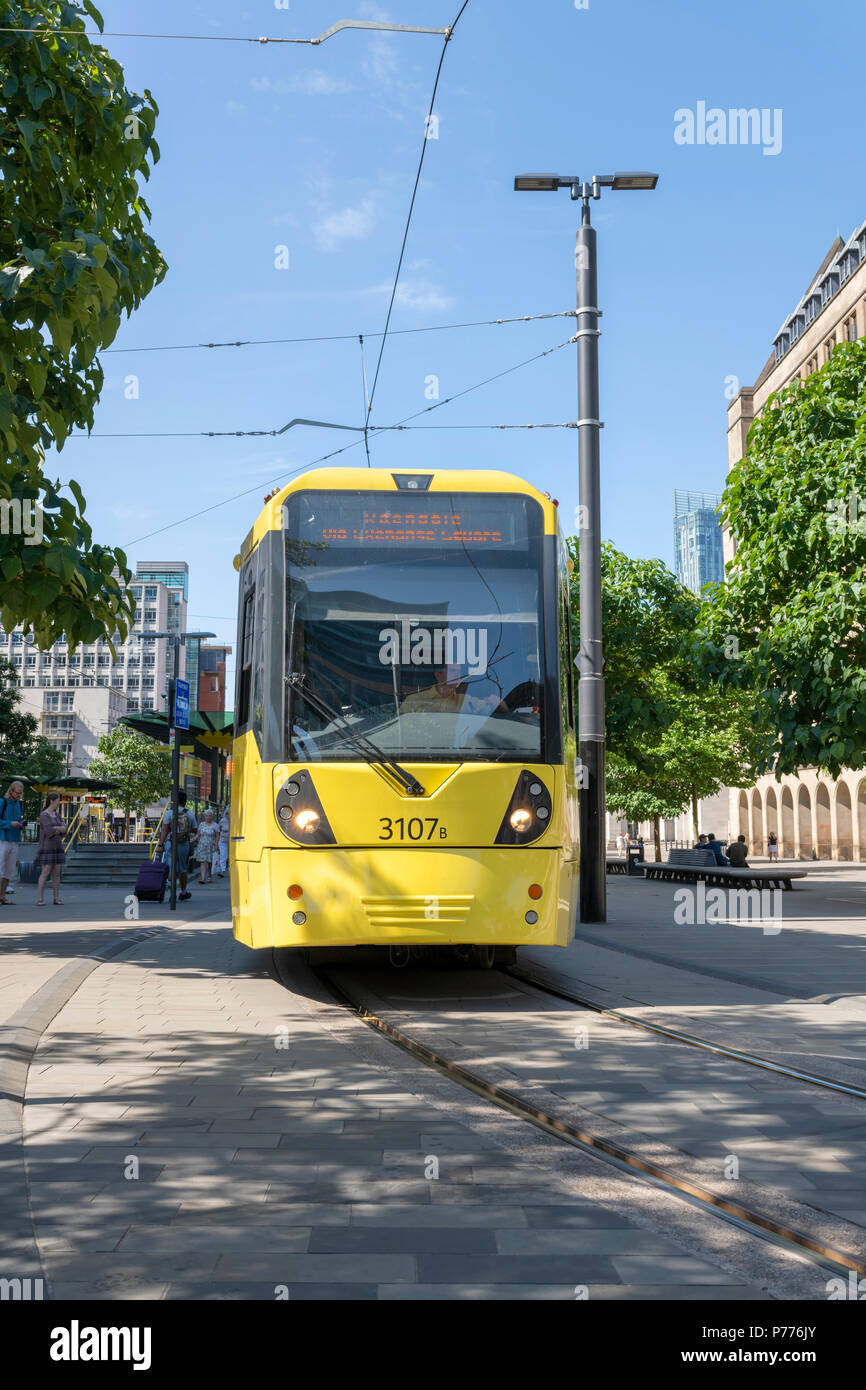 Moderno tram Metrolink prelevare i passeggeri presso il St Peters Square nel centro di Manchester, Regno Unito Foto Stock