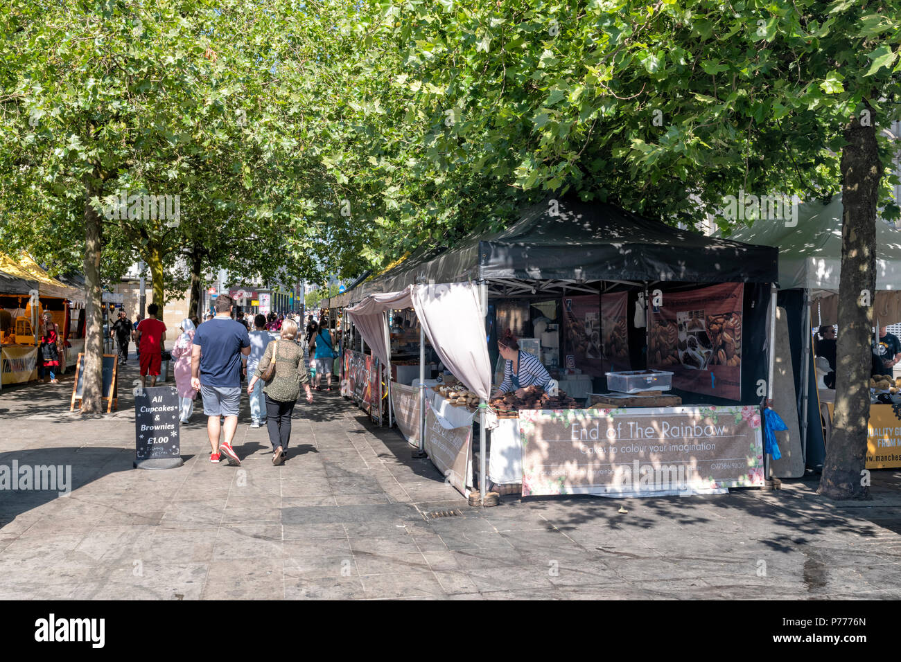 Fresatura di persone intorno a varie bancarelle prodotti alimentari in un mercato aperto, vicino a Piccadilly Gardens nel centro di Manchester, Regno Unito Foto Stock