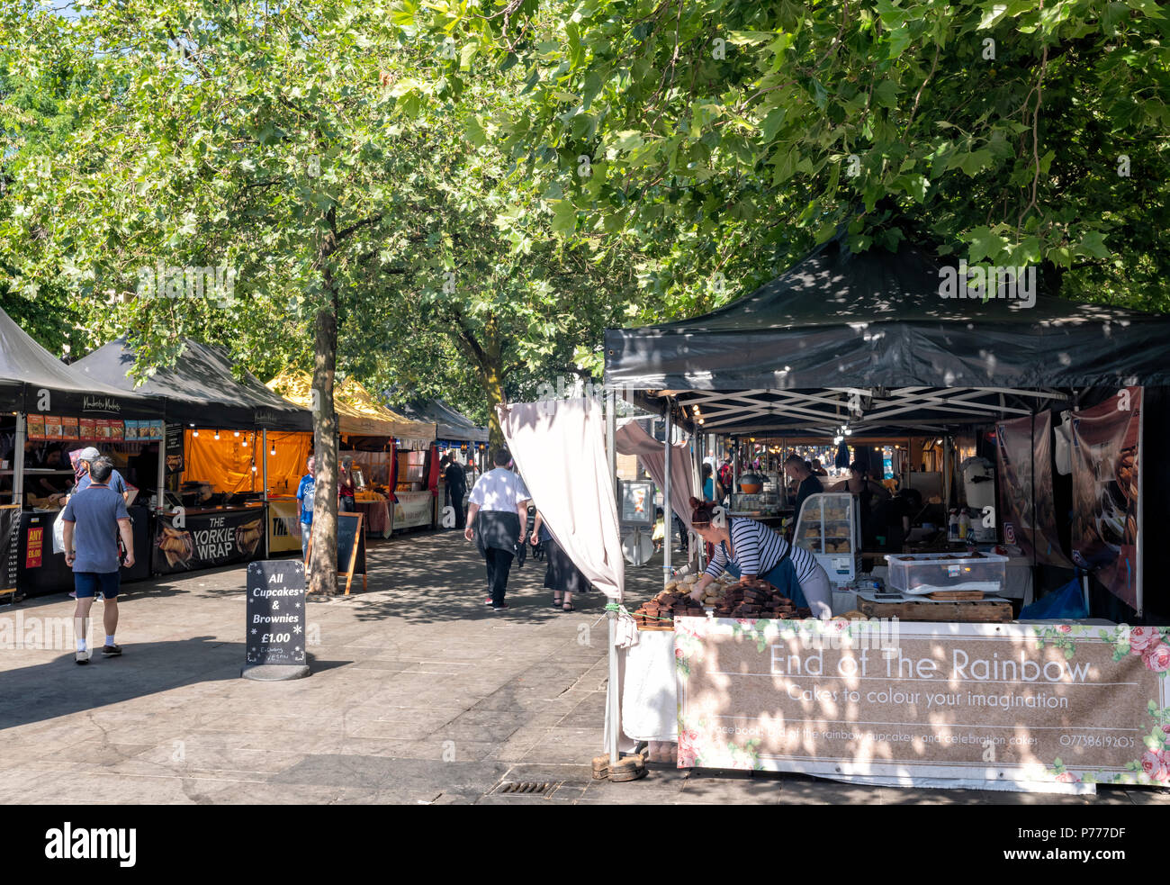 Fresatura di persone intorno a varie bancarelle prodotti alimentari in un mercato aperto, vicino a Piccadilly Gardens nel centro di Manchester, Regno Unito Foto Stock