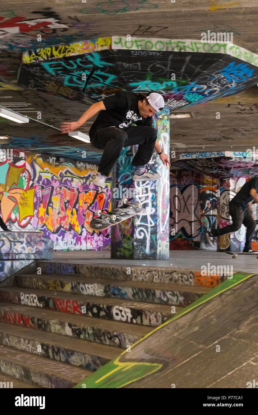 Londra Southbank Skatepark graffiti guidatore di skateboard in volo giù per le scale passi lo skateboard jump trucco azione acrobatica di specialità Foto Stock