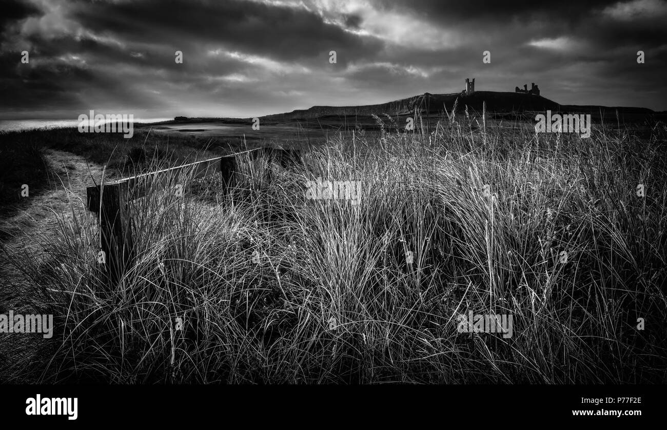 Il castello di Dunstanburgh lunga esposizione in bianco e nero Foto Stock