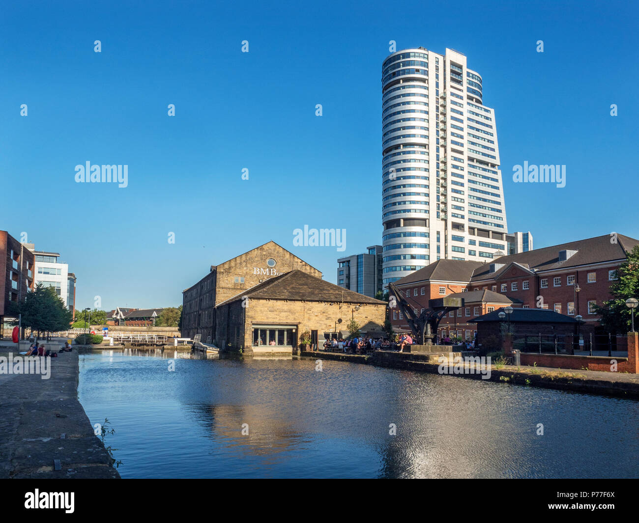 Le persone al di fuori in una serata estiva a Granary Wharf con Bridgewater posto alle spalle di Leeds West Yorkshire Inghilterra Foto Stock