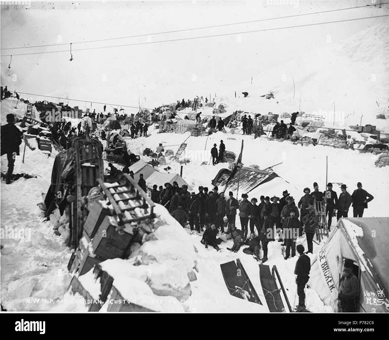 . Inglese: Nord-Ovest polizia montata e Canadian custom house sul vertice Chilkoot, Alaska, ca. 1898. Inglese: Mostra Klondikers con cache di alimentazione . Didascalia sulla immagine: "N.W.M.P. e Canadian custom house sul vertice Chilkoot' fotografia originale da Eric A. Hegg 211; copiati da Webster e Stevens 164.A . Klondike Gold Rush. Soggetti (LCTGM): slitte e slittini--Alaska--Chilkoot Pass; Customhouses--Alaska--Chilkoot Pass soggetti (LCSH): Chilkoot Pass (Alaska); valichi di montagna--Alaska; Chilkoot Trail; percorsi--Alaska; a nord ovest di polizia montata (Canada) . circa 1898 10 Nord-Ovest polizia montata e Canad Foto Stock