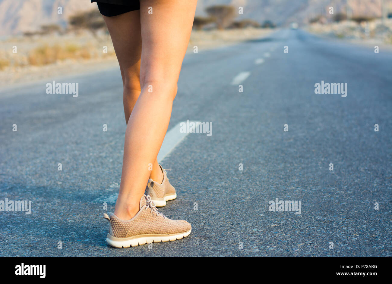 Femminile su strada nel deserto a basso angolo di visione Foto Stock