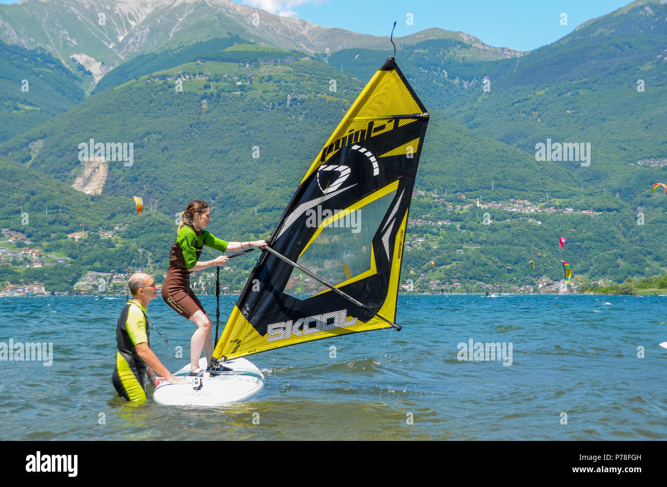 Il lago di Como, Italia - Giugno 9th, 2018: Docente e gli studenti di indossare muta in acqua fredda del Lago di Como ad apprendere come windsurf su una bella somma Foto Stock