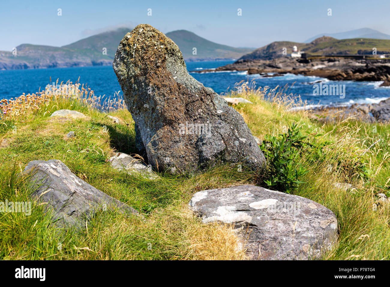 Piccola pietra permanente e Valentia Island Lighthouse in background, nella contea di Kerry, Irlanda Foto Stock