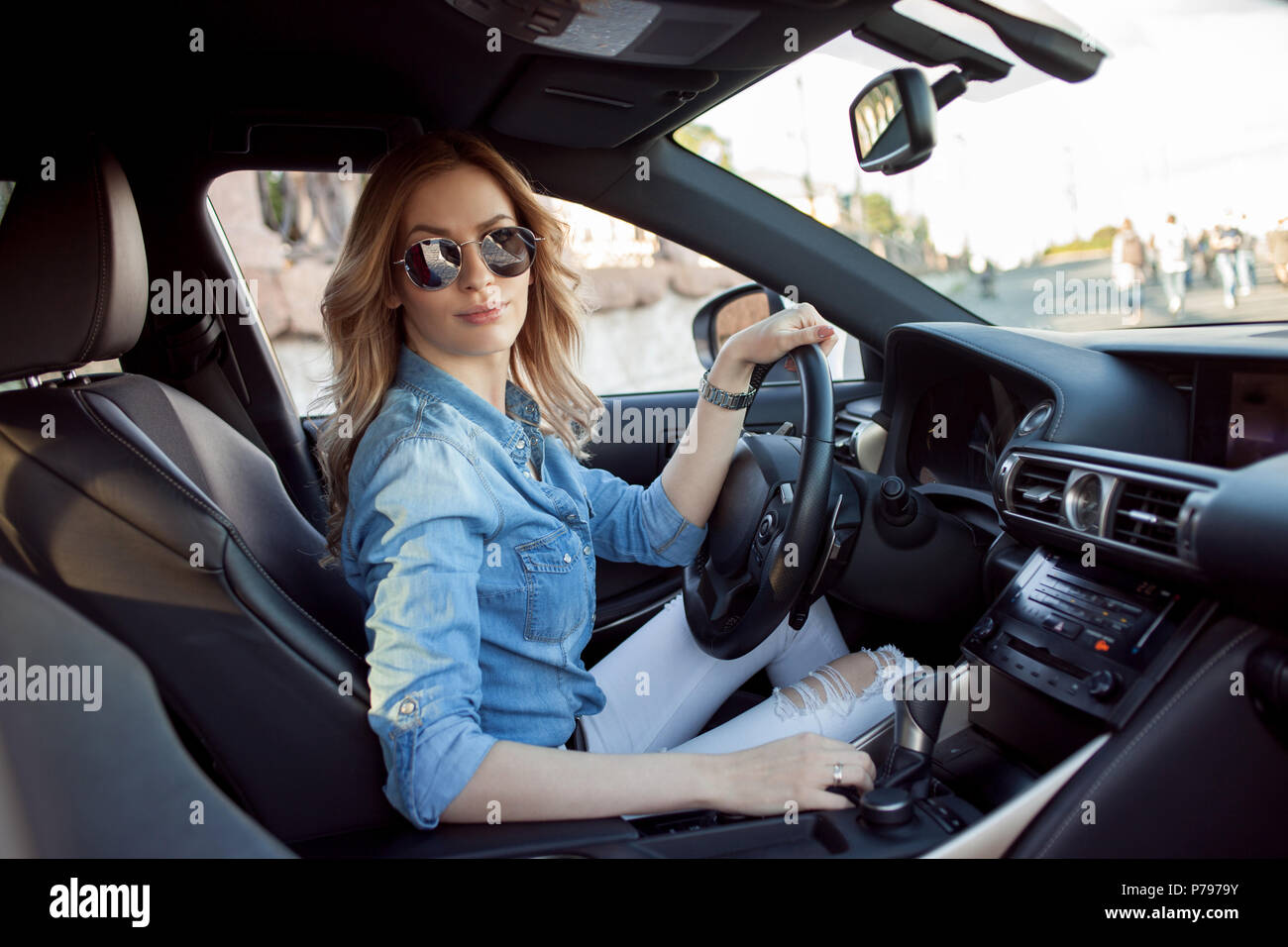 Giovane donna attraente la guida la sua auto. Ritratto di una donna d'affari di successo, stile casual Foto Stock