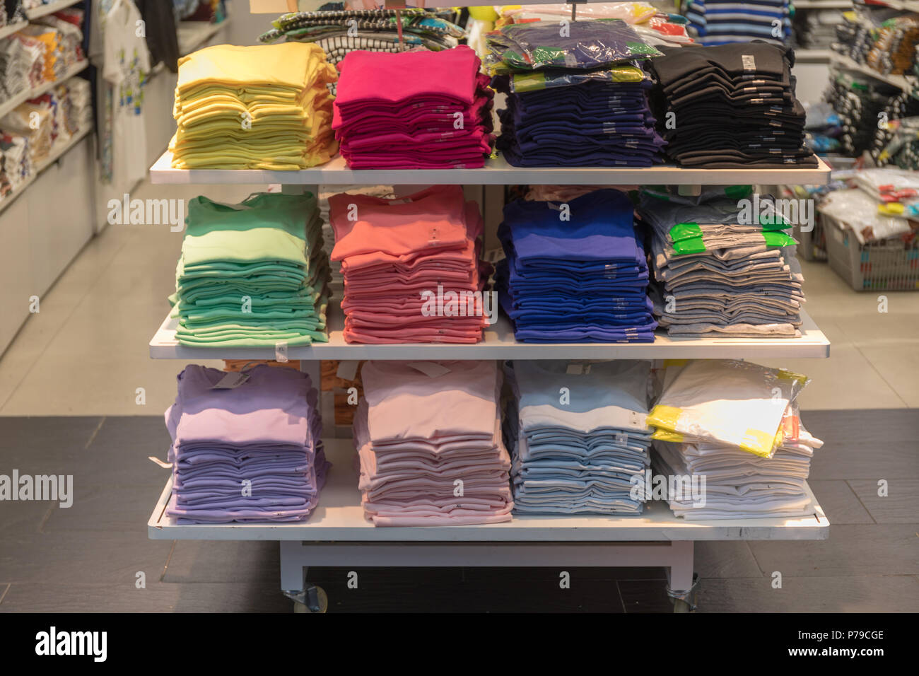 Grande pila di moderna magliette colorate impilati nel ripiano Foto Stock