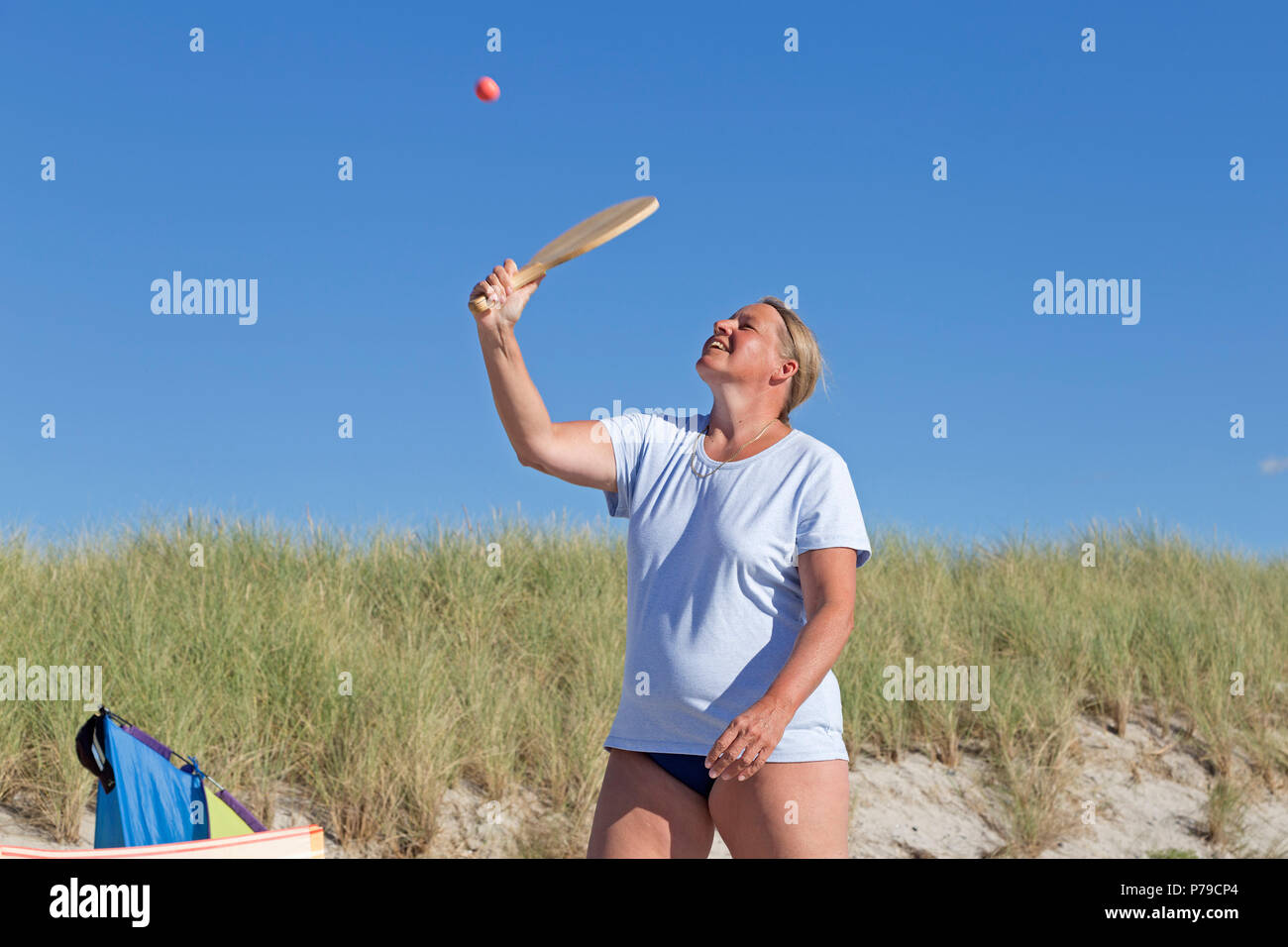 Donna che gioca a palla sulla spiaggia, spiaggia, Wustrow, Fischland, Meclemburgo-Pomerania Occidentale, Germania Foto Stock