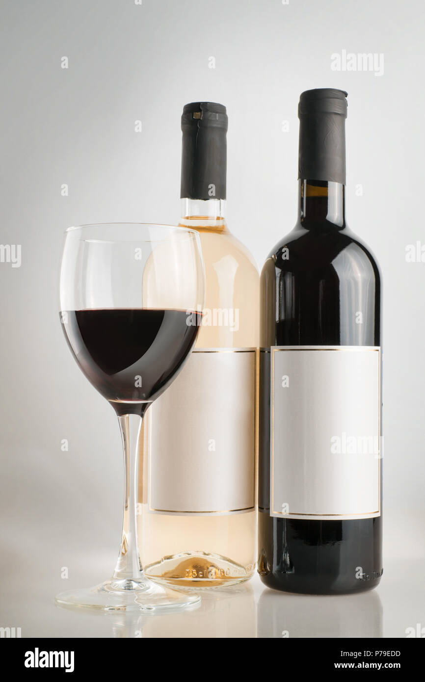 Vino rosso e bianco di bottiglie con etichette vuote e vino rosso in vetro. Su sfondo bianco Foto Stock