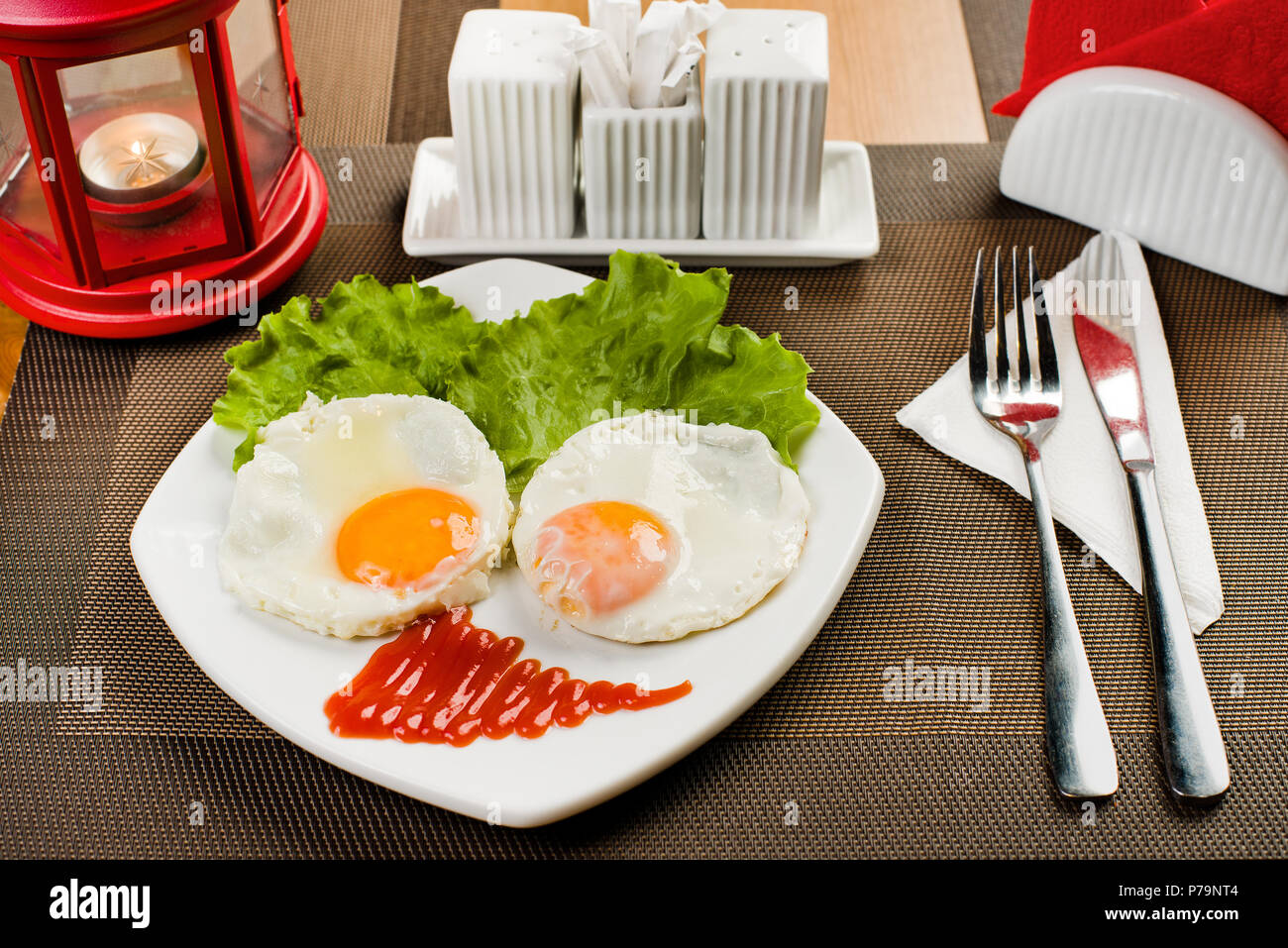 Ceramica piastra bianca con insalata e uova fritte, sul tavolo nel ristorante Foto Stock