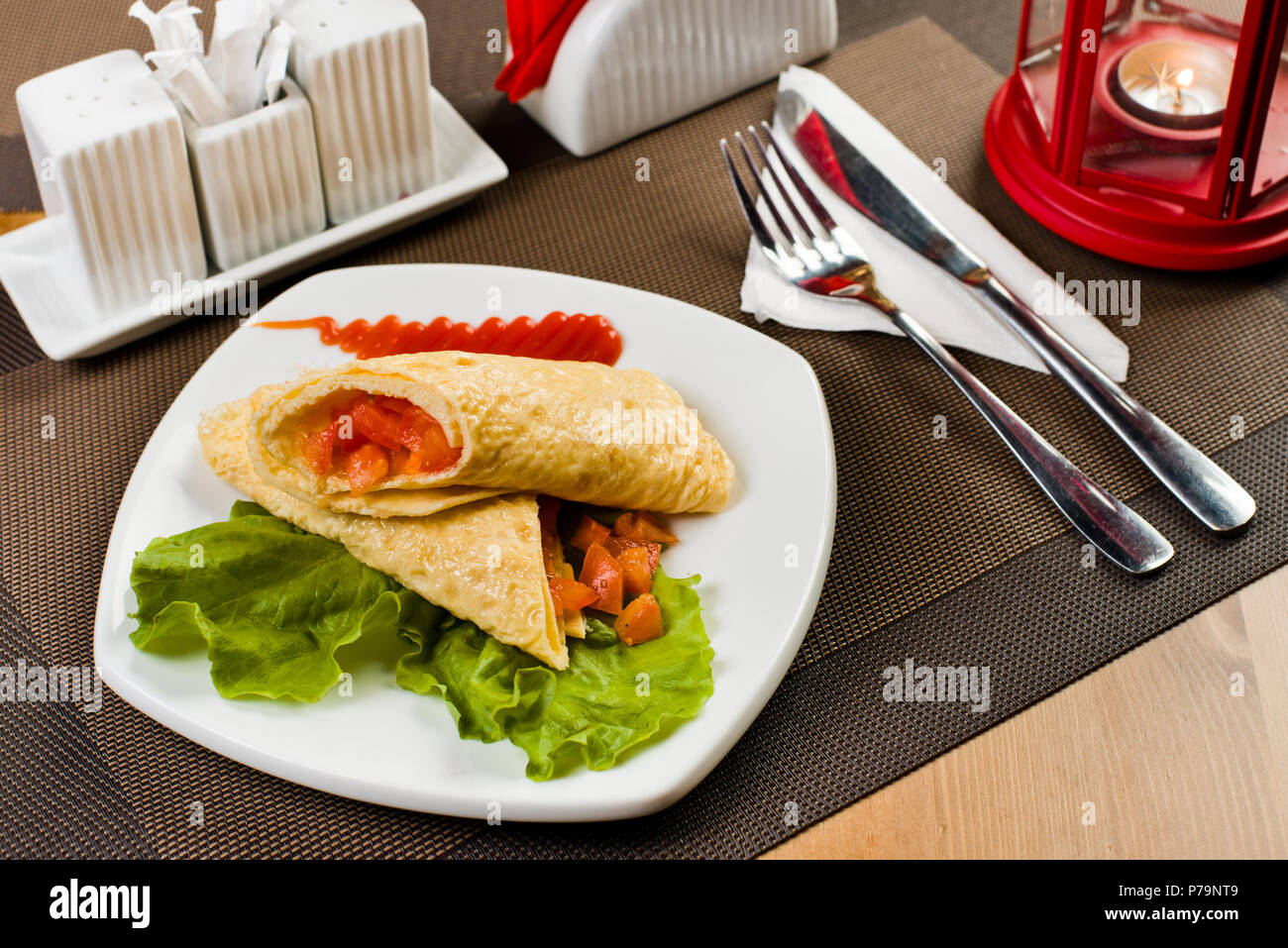 Ceramica piastra bianca con insalata di frittata e verdure ripiene, sul tavolo nel ristorante Foto Stock