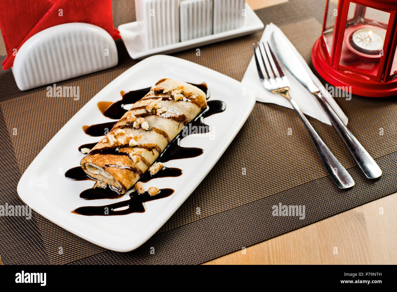 Ceramica piastra bianca con frittella dolce e cioccolato, dessert sul tavolo nel ristorante Foto Stock